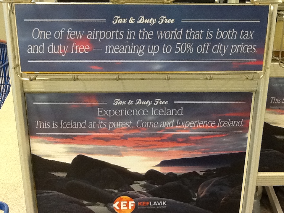 Sign reading: One of the few airports in the world which is both tax and duty free, meaning up to 50% off city prices. Experience Iceland. This is Iceland at it’s purest. Come and Experience Iceland.